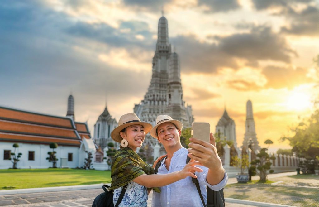 Couple love romantic selfie at Wat Arun Bangkok or Arun temple which famous travel destination in Thailand in travel trip during vacation for relaxation. Lifestyle couple travel destination concept.