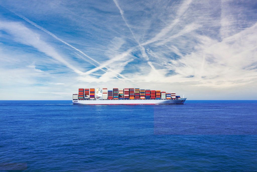 Freight transportation - A large cargo container ship transporting hundreds of multi coloured containers across the sea